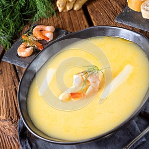 Delicious asparagus cream soup with prawns and fresh dill