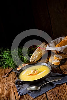 Delicious asparagus cream soup with prawns and fresh dill