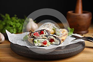 Delicious baked eggplant rolls served on wooden table
