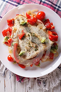 Delicious baked flounder with vegetables closeup. vertical top v