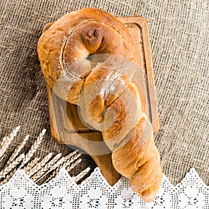 Delicious baked goods on a wooden cutting board, near the wheat.