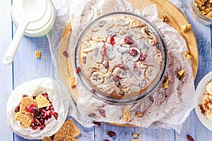 Delicious banana cake with nuts, sesame and cranberry on a wooden table