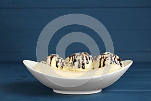 Delicious banana split ice cream on blue wooden table