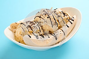 Delicious banana split ice cream with toppings on light blue background