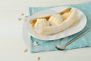 Delicious banana split ice cream on white wooden table