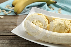 Delicious banana split ice cream on wooden table, closeup