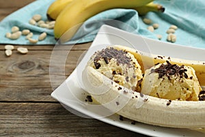 Delicious banana split ice cream on wooden table, closeup