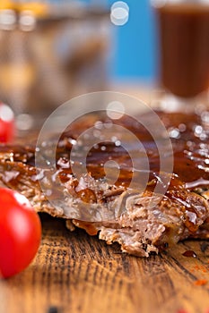 Delicious barbecued ribs seasoned with a spicy basting sauce and served with chopped fresh vegetables on an old rustic