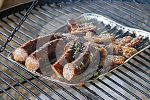Delicious barbecued sausages sizzling over a campfire.