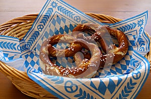 Delicious Bavarian Brezeln or pretzels with a brown salty crust on a traditional Bavarian cocktail napkin in a basket