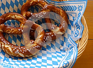 Delicious Bavarian Brezeln or pretzels with a brown salty crust on a traditional Bavarian cocktail napkin in a basket