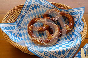 Delicious Bavarian Brezeln or pretzels with a brown salty crust on a traditional Bavarian cocktail napkin in a basket