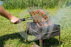 Delicious bbq kebab grilling on open grill, outdoor kitchen. tasty food roasting on skewers, food-court. summer picnic