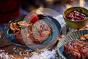 Delicious BBQ steaks and vegetables on table