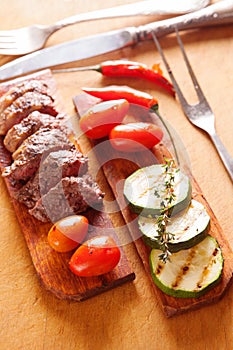 Delicious beef steak with vegetable over wooden table