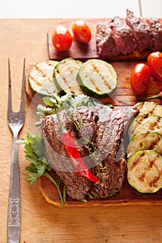 Delicious beef steak with vegetable over wooden table