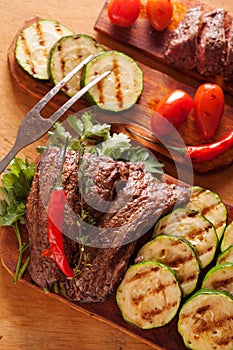 Delicious beef steak with vegetable over wooden table