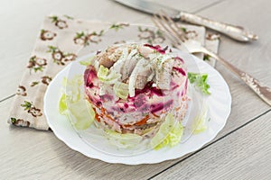 Delicious beetroot salad with herring on a served table
