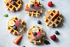 Delicious Belgian waffles with berries on a gray background. Top view