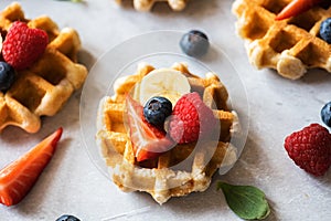 Delicious Belgian waffles with berries on a gray background. Top view