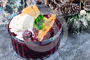 Delicious Berry cobbler in glass ramekin with ice cream, Christmas decoration, horizontal