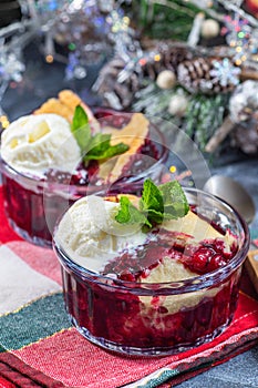 Delicious Berry cobbler in glass ramekin with ice cream, Christmas decoration, vertical