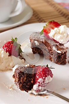 Delicious Bite of Chocolate Brownie and Strawberry with Whipped