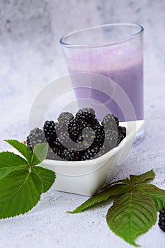 Delicious blackberry smoothie with fresh berries in glasses bowl.