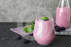 Delicious blackberry smoothie in glassware on table