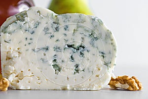 Delicious blue cheese dorblu or gorgonzola with pear and walnuts on white background. Close up