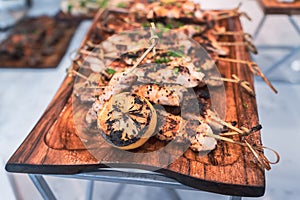 Delicious board of chicken skewers served with grilled lemon.