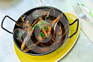 Delicious boiled mussels with tomato sauce and parsley photo