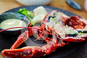 Delicious Boiled Red Lobster Halves Served on Elegant Black Plate at Restaurant