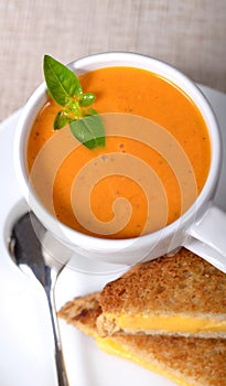 Delicious bowl of tomato soup with grilled cheese sandwich