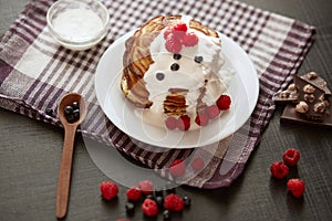 Delicious breackfast for family, pancackes with sour cream and berries, kitchen table decorated with raspberries, blueberries,