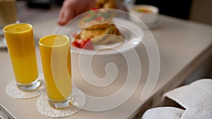 Delicious breakfast in bed. Close-up of a salad bowl and two glasses of orange juice on a table in a minimalist dining