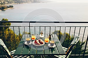 Delicious breakfast with coffee, pastry, and orange juice served on the balcony with sea view