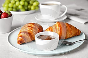 Delicious breakfast with croissants and chocolate served on table