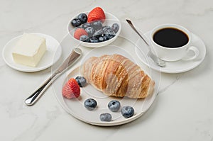 Delicious breakfast with fresh coffee, fresh croissants and berries. Selective focus
