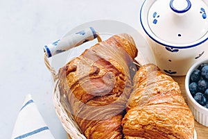 Delicious breakfast with fresh croissants and blueberry on light background, bright fresh mood