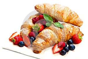 Delicious breakfast with fresh croissants and ripe berries