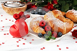 Delicious breakfast with fresh croissants and ripe berries and mint for valentines day