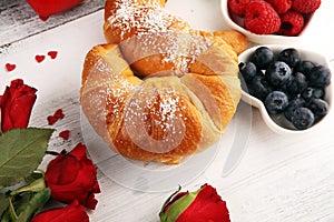 Delicious breakfast with fresh croissants and ripe berries and mint for valentines day