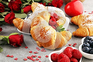 Delicious breakfast with fresh croissants and ripe berries and mint for valentines day