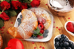 Delicious breakfast with fresh croissants and ripe berries and mint for valentines day