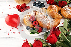 Delicious breakfast with fresh croissants and ripe berries and mint for valentines day