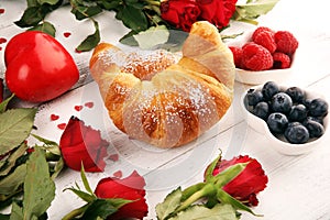 Delicious breakfast with fresh croissants and ripe berries and mint for valentines day