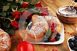 Delicious breakfast with fresh croissants and ripe berries and mint for valentines day