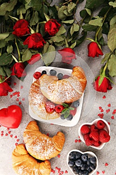 Delicious breakfast with fresh croissants and ripe berries and mint for valentines day