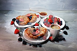 Delicious breakfast with fresh croissants and ripe berries on old marble background.